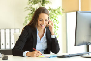 Vrouw belt en zit achter bureau